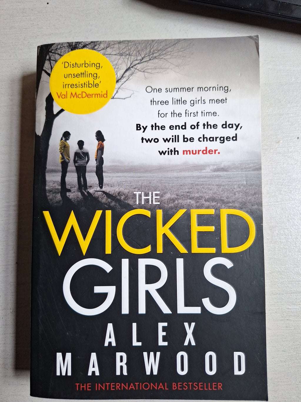The Wicked Girls book by Alex Marwood with dark cover featuring three girls under a tree and a suspenseful tagline