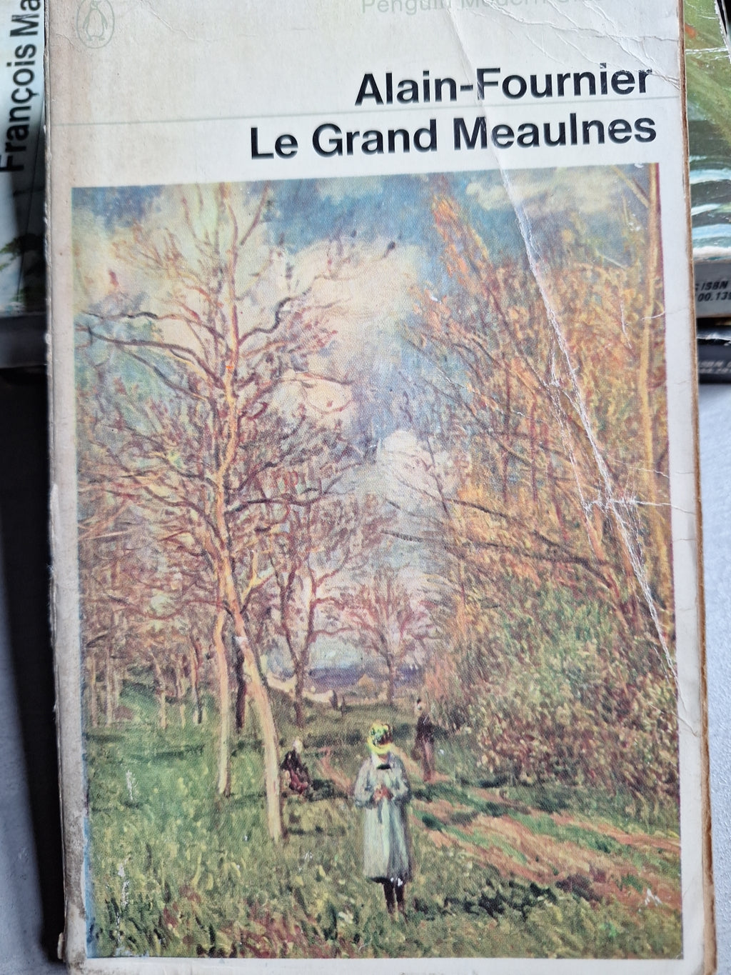 Slightly worn copy of Le Grand Meaulnes by Alain-Fournier with illustrated tree landscape cover