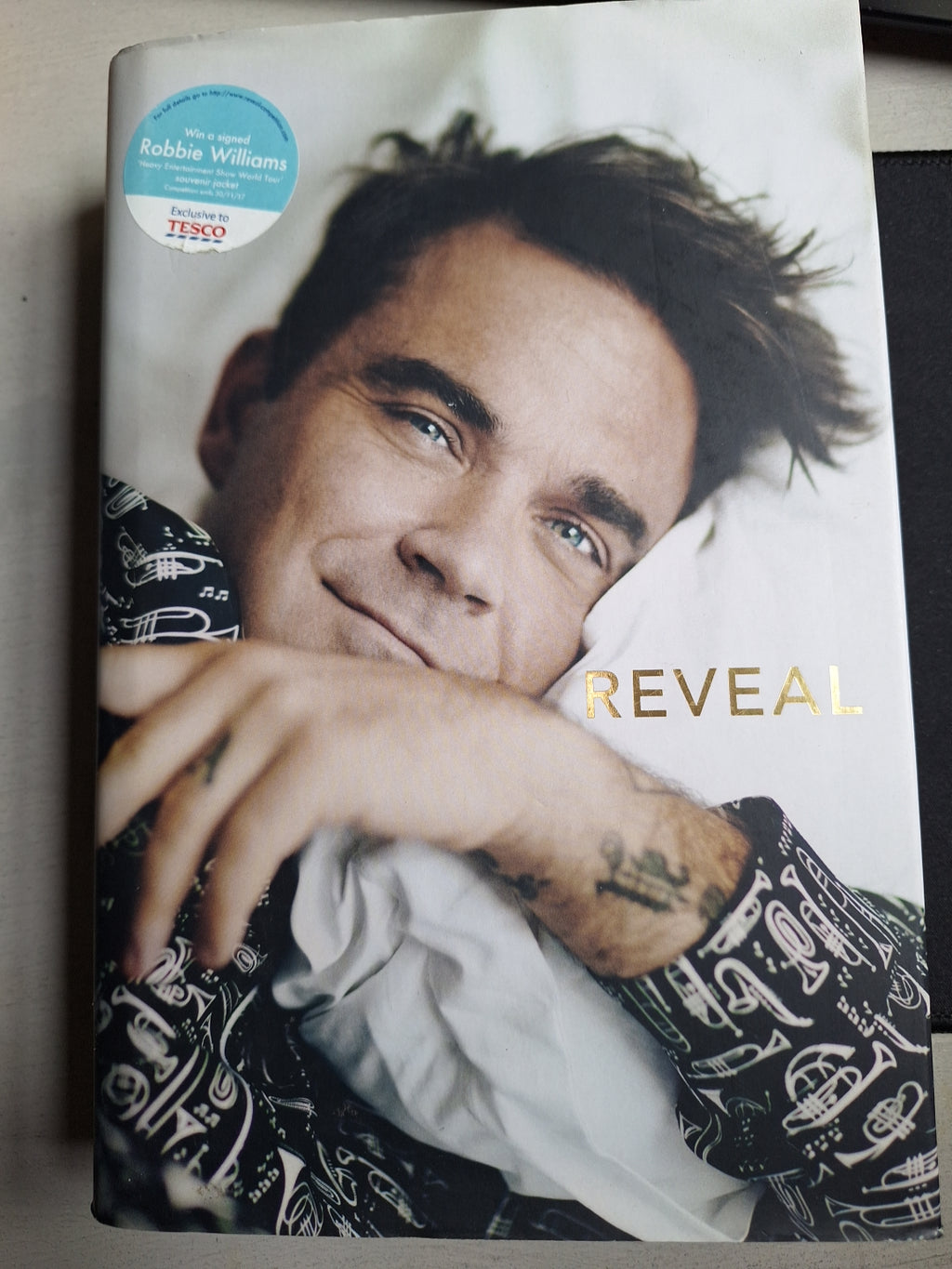 Reveal book featuring Robbie Williams on the cover, a Robbie Williams biography book by Slightly Read Books