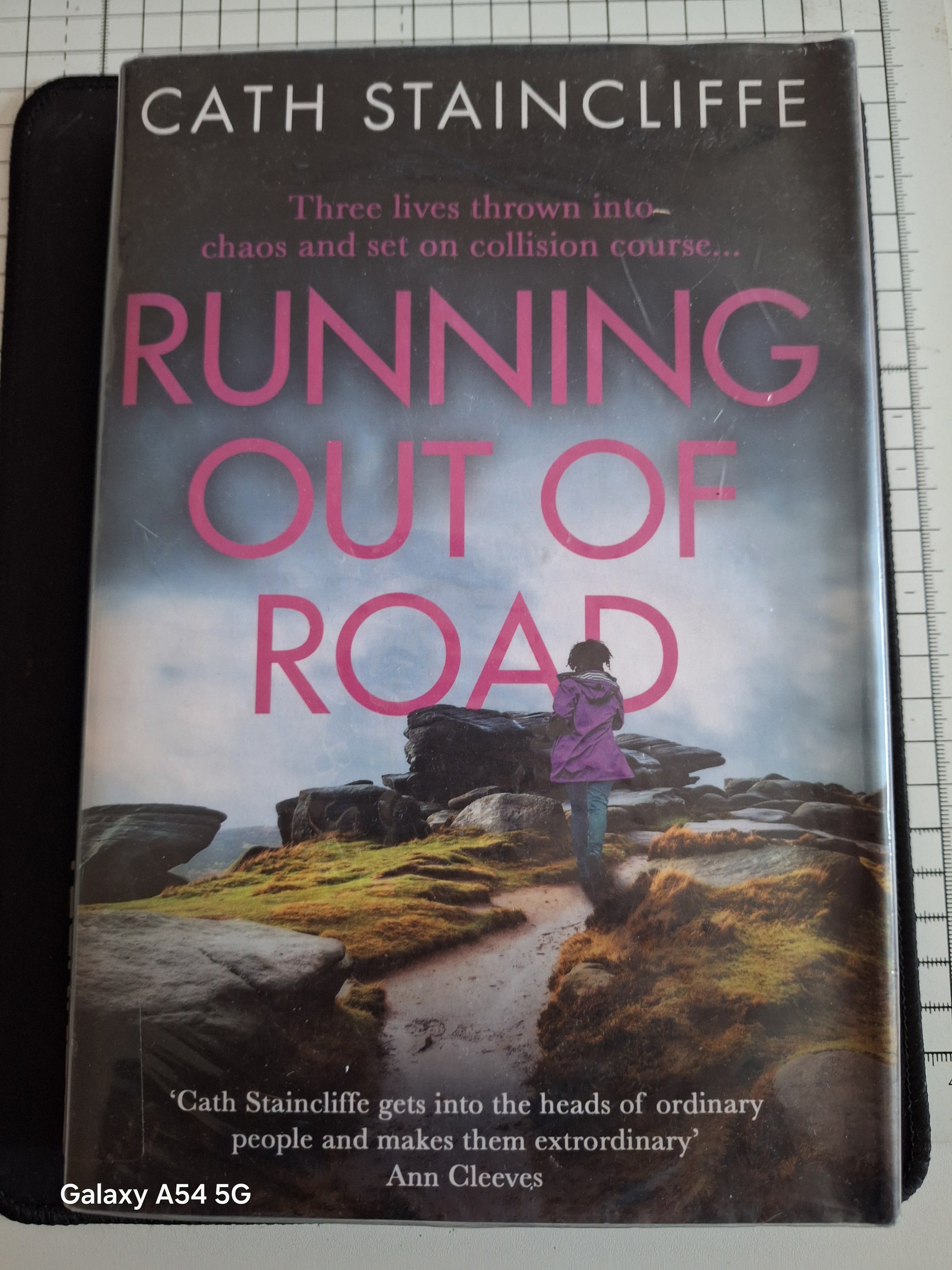 Running out of road book by Cath Staincliffe with a person walking on a rugged path amidst rocks and grass