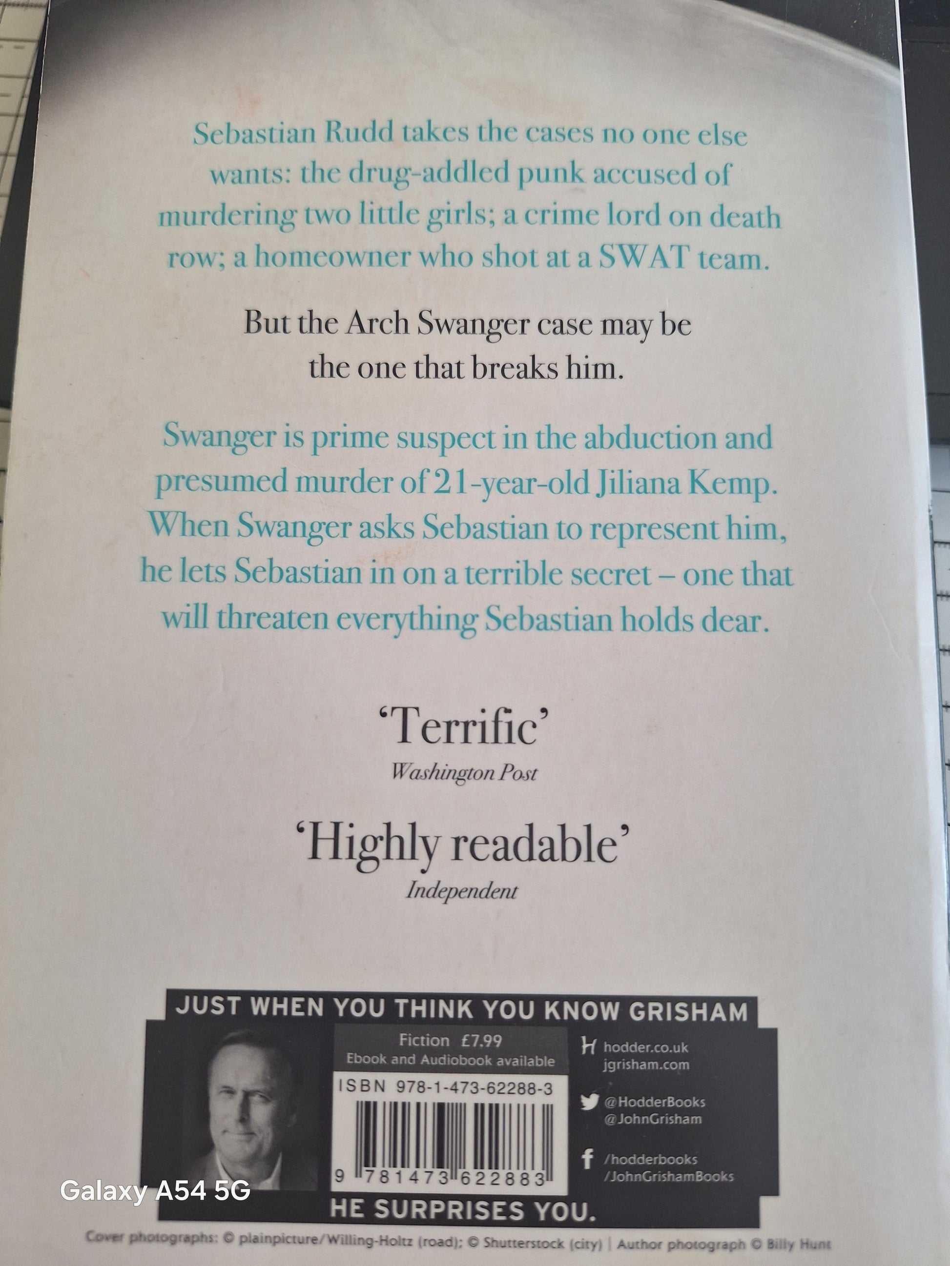 Back cover of a second hand John Grisham novel featuring a gripping synopsis and reviews