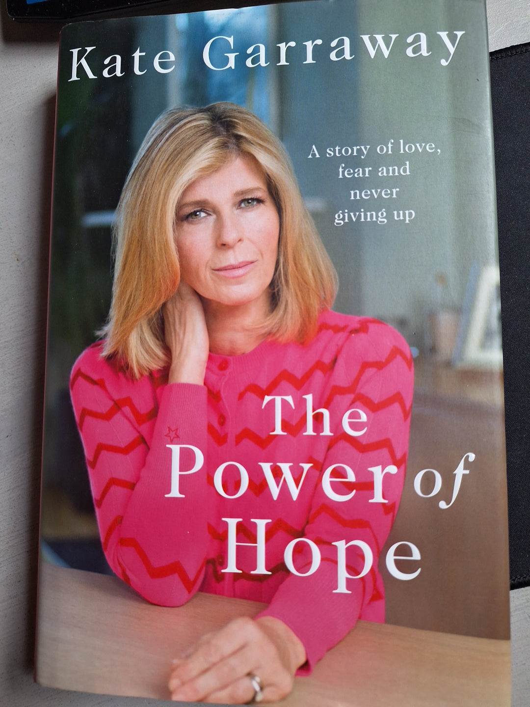 The power of hope book by Kate Garraway featuring her portrait in a pink patterned sweater