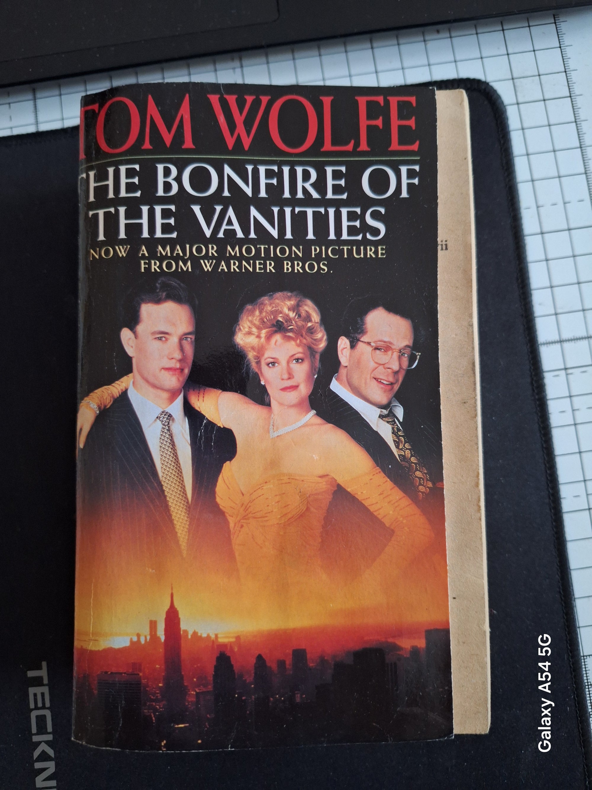 The bonfire of the vanities book by Tom Wolfe with cover showing film adaptation characters and city skyline