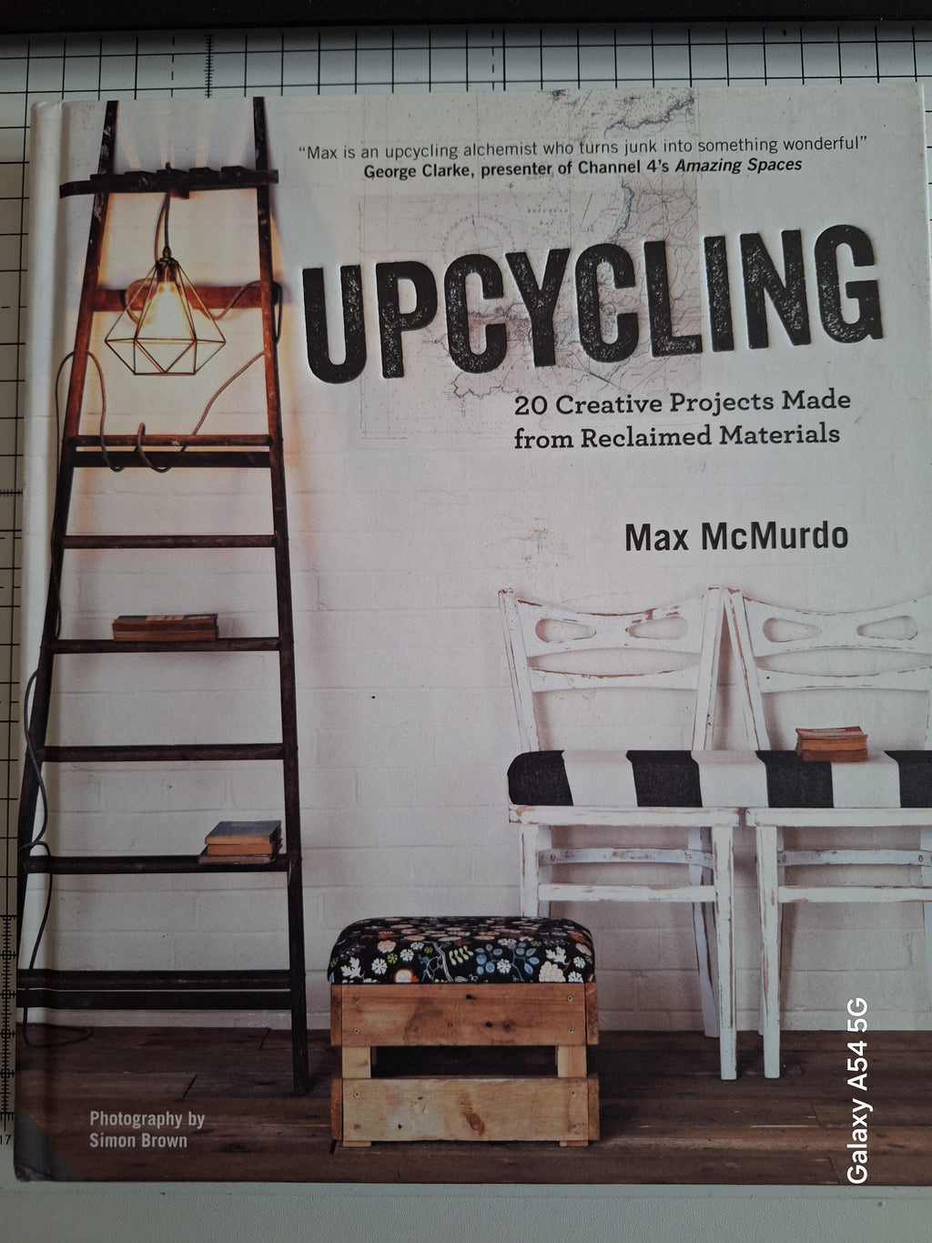Upcycling book by Max McMurdo featuring creative projects made from reclaimed materials with a rustic ladder and chairs background