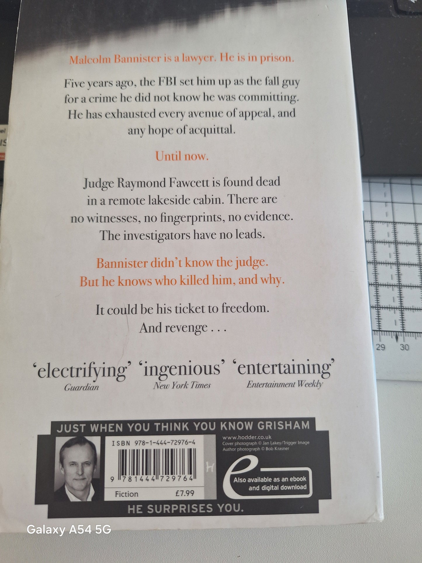Used John Grisham The Racketeer book with a gripping back cover description and price tag